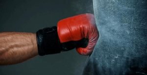 hitting the heavy bag by using boxing gloves